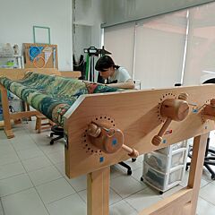 Conservator working on a large tapestry using EX-LIBRIS Adjustable Textile Conservation Workstation